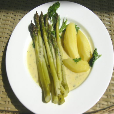 Tellergericht mit gruenem Spargel und Kartoffeln in Sauce