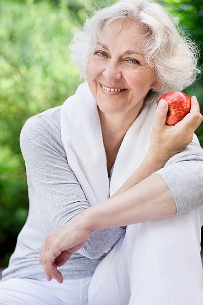 alte frau lächelnd mit apfel